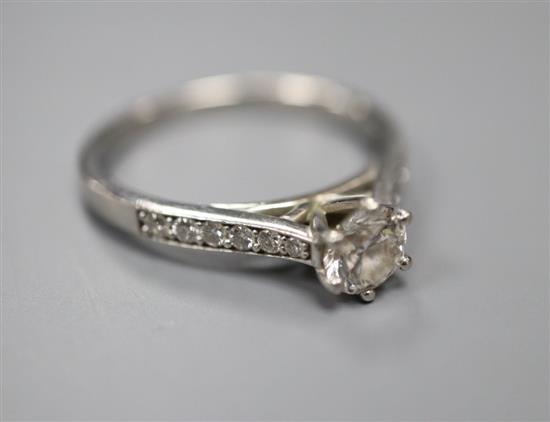 A modern platinum and single stone diamond ring, with diamond set shoulders, size N, gross 4.5 grams.